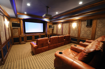 home theater with custom cabinetry and theater seating in large media room 